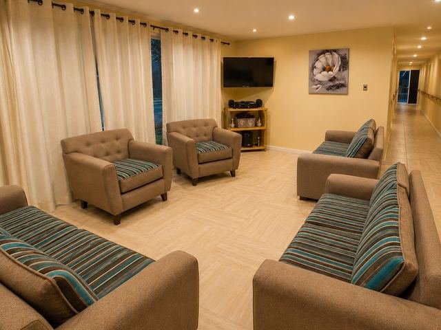 Living con sillones de tela y televisor, junto al pasillo con pasamanos