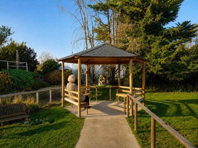 Pérgola de madera con techo a dos aguas en medio del jardín